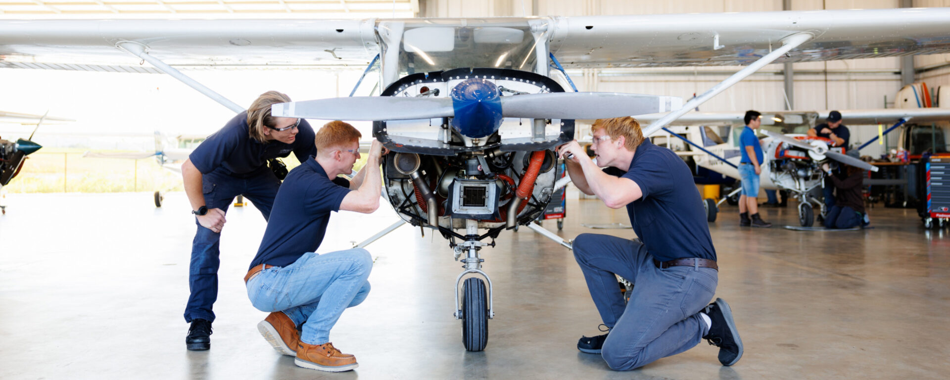 Students at Liberty University's Aviation Maintenance Technical Program working on a plane